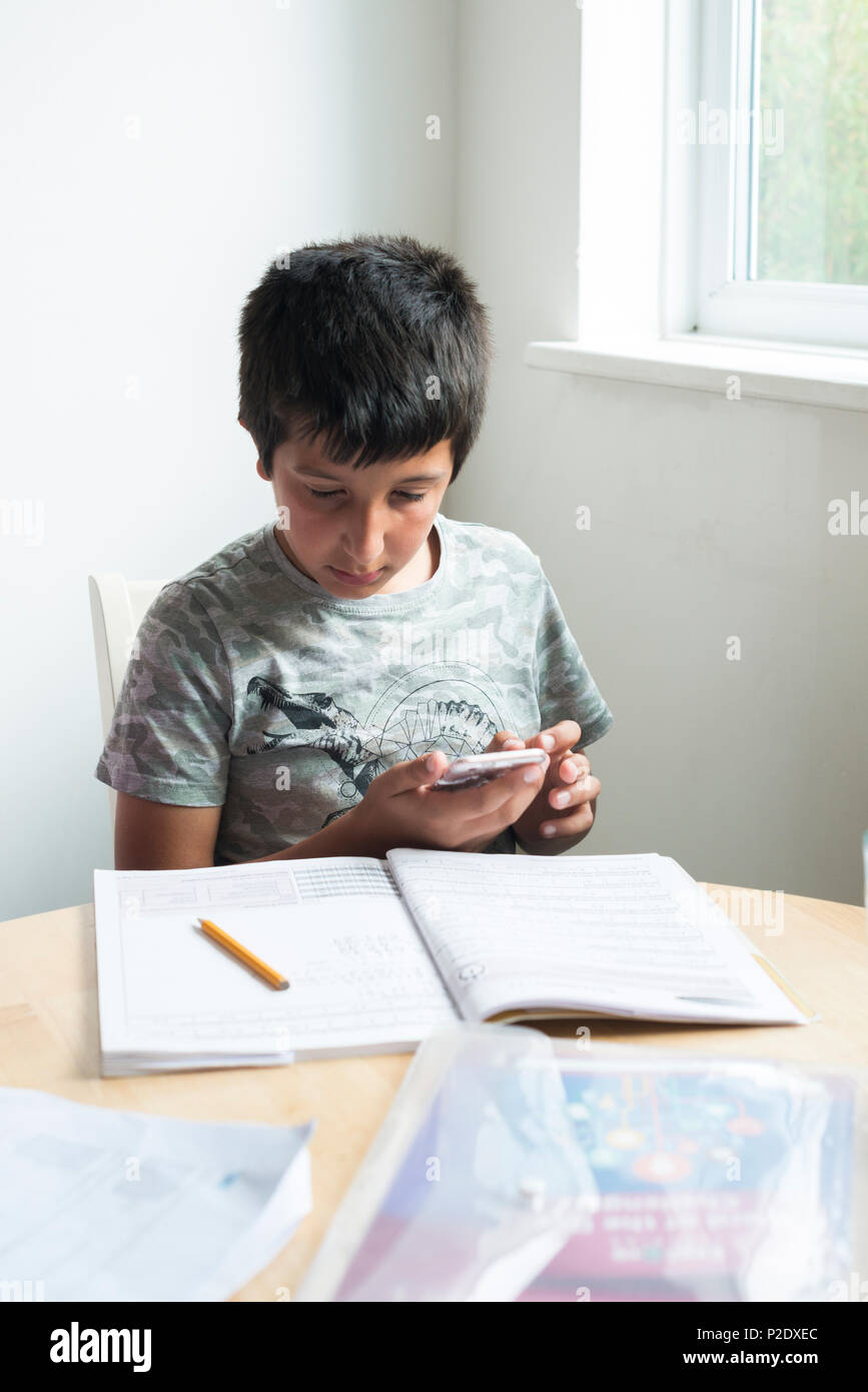 Schüler -10-11 Jahre alt mit Smartphones zu Hausaufgaben, Surrey, Großbritannien Stockfoto