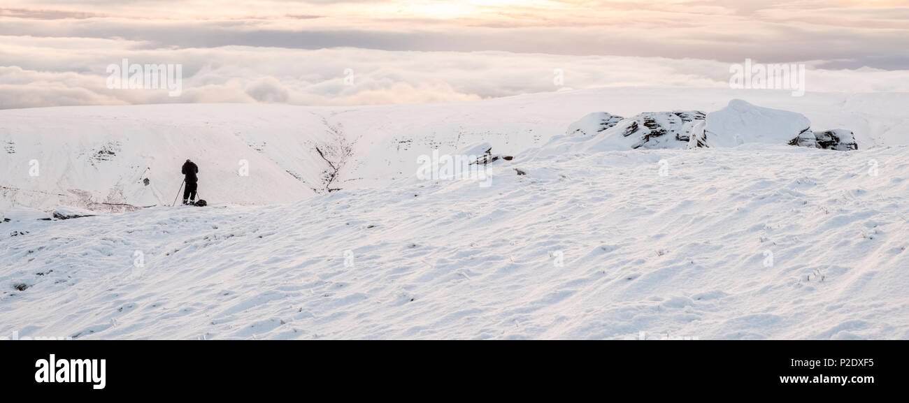 Fotograf, Peak District Landschaft Blick auf den Schnee, Hügel und eine Wolke Inversion in der Ferne Kinder Scout, Derbyshire, England, Großbritannien Stockfoto