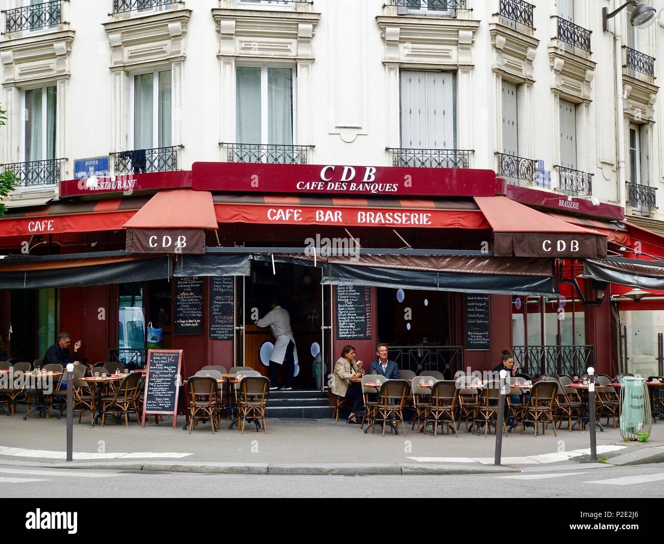 Kellner gerade auf der Innenseite der Tür des CDB, Cafe des Banques, während Leute sitzen auf der Terrasse des Restaurants Paris, Frankreich Stockfoto