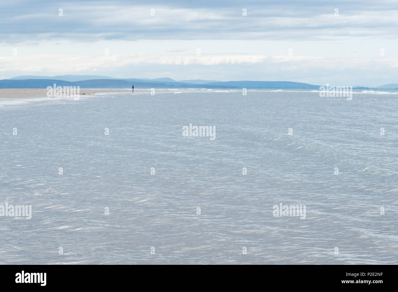 Kleine männliche Figur stehend auf leeren Strand mit Blick auf Meer, Strand, Bucht, Burghead Findhorn, den Moray Firth, Schottland, Großbritannien Stockfoto