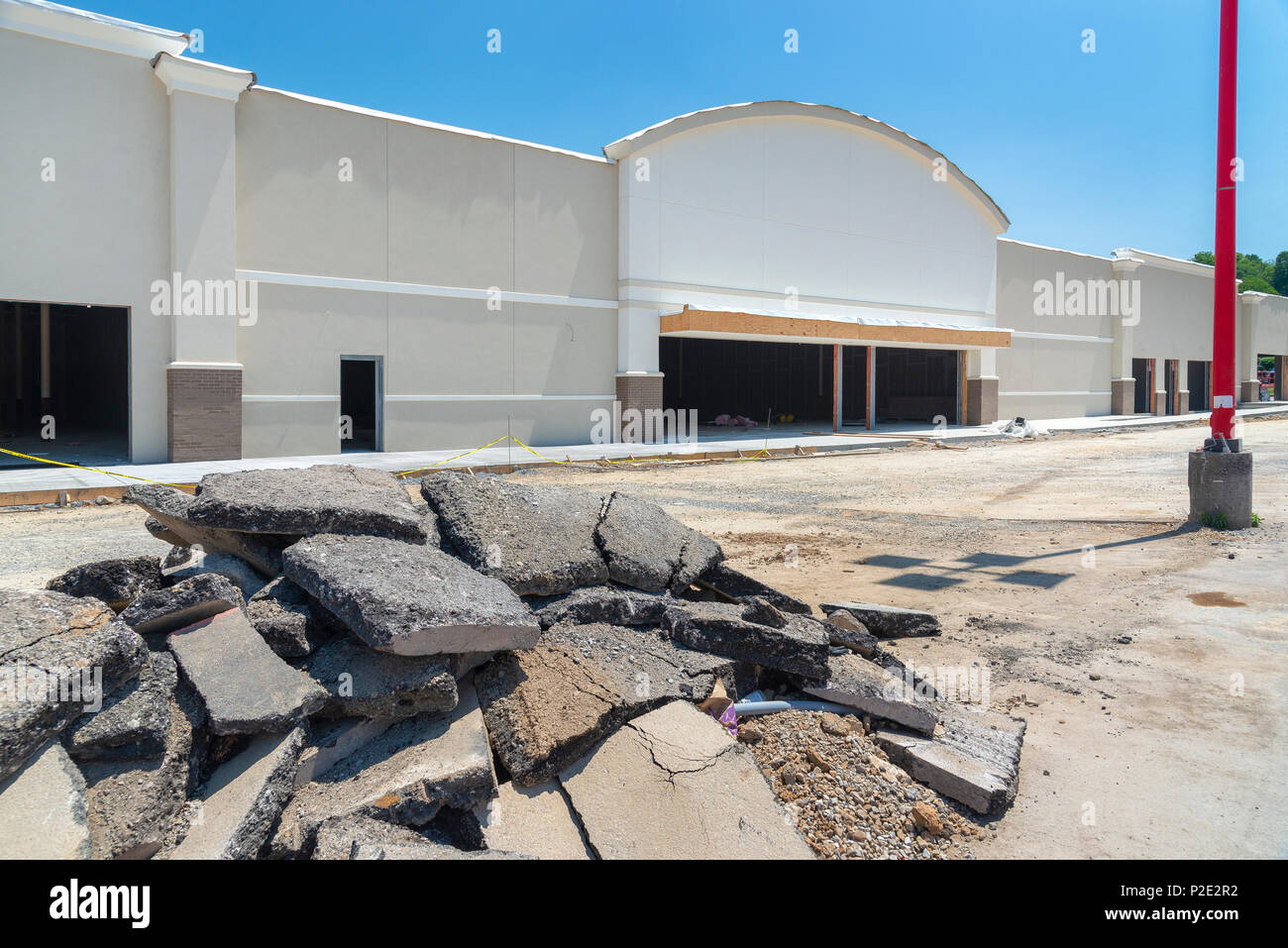 Neuen streifen Einkaufszentrum im Bau. Es gibt einen großen Haufen von zerrissen Pflaster im Vordergrund. Stockfoto