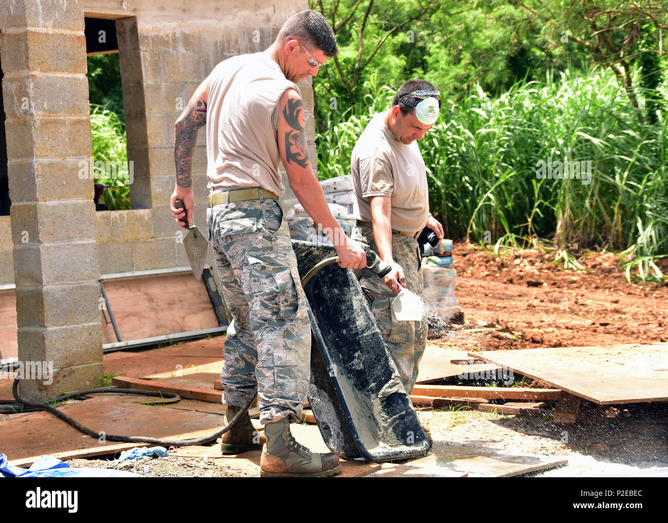 Master Sgt. Joshua Cloutier (links) und Älterer Flieger John Bender von der 143d Tiefbau Squadron (CES), Rhode Island Air National Guard spülen Zement aus Tools für Beschichtung, stärkt die Wände für extreme Wetterbedingungen in Inarajan, Guam während einer innovativen Readiness Training (IRT) Projekt am 5. September 2016 Skim verwendet. Das IRT-Projekt, das in Verbindung mit Lebensraum für die Menschheit Guam ist zwei Häuser für Bewohner in Inarajan zur Verfügung zu stellen. Die Mitglieder sind Teil einer 36 Flieger Crew aus einem Querschnitt der Trades innerhalb der CES. Us Air National Guard Foto von Master Sgt. John V. McD Stockfoto