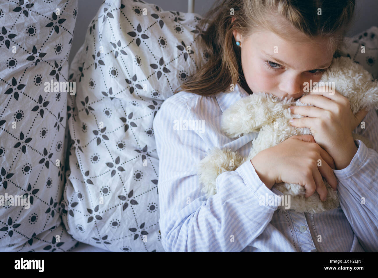 Mädchen mit Teddybär auf Bett Stockfoto