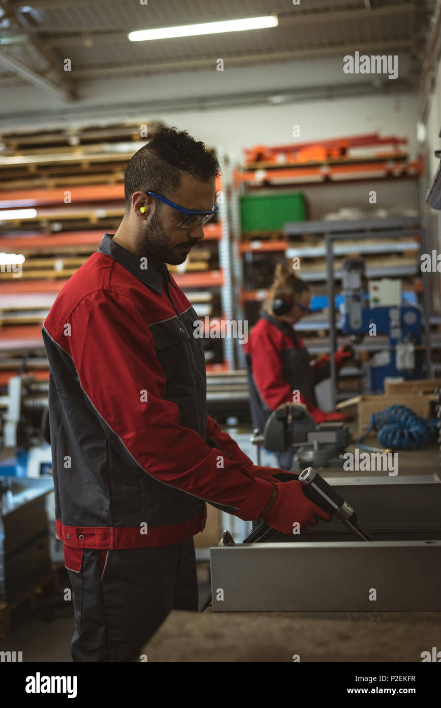 Männliche Arbeiter Reparatur einer Maschine mit Werkzeug Stockfoto