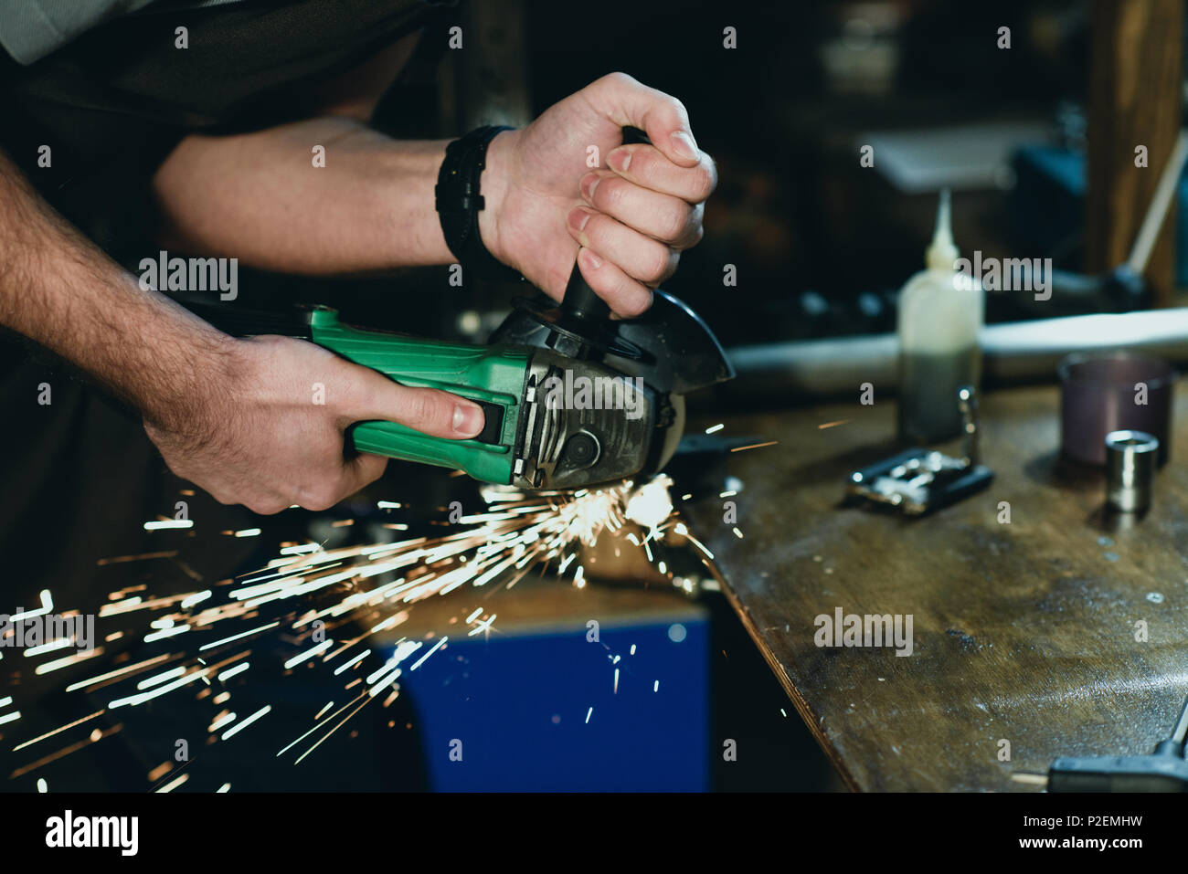 Close-up Teilansicht des Menschen Schneiden von Metall mit dem Winkelschleifer in Werkstatt Stockfoto