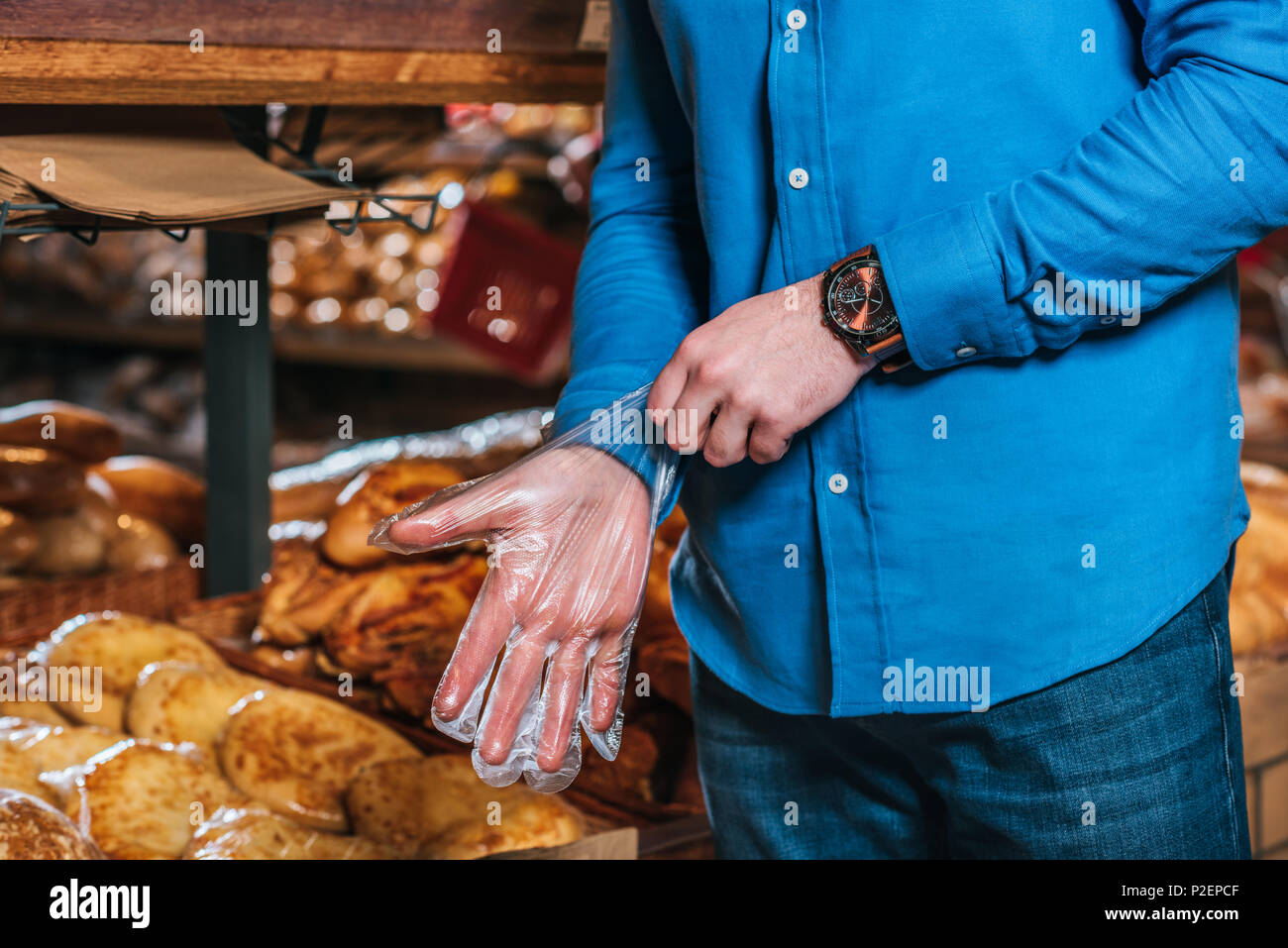 7/8 Schuß von Mann mit Einweg Handschuh in Lebensmittelgeschäft Stockfoto