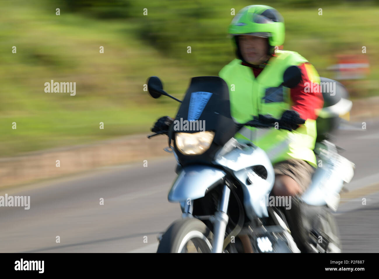 Durban, KwaZulu-Natal, Südafrika, event Marschall, gut sichtbare Kleidung, die Durchführung von dienstlichen Pflichten auf Motorrad, 2018 Comrades Marathon, blur Stockfoto