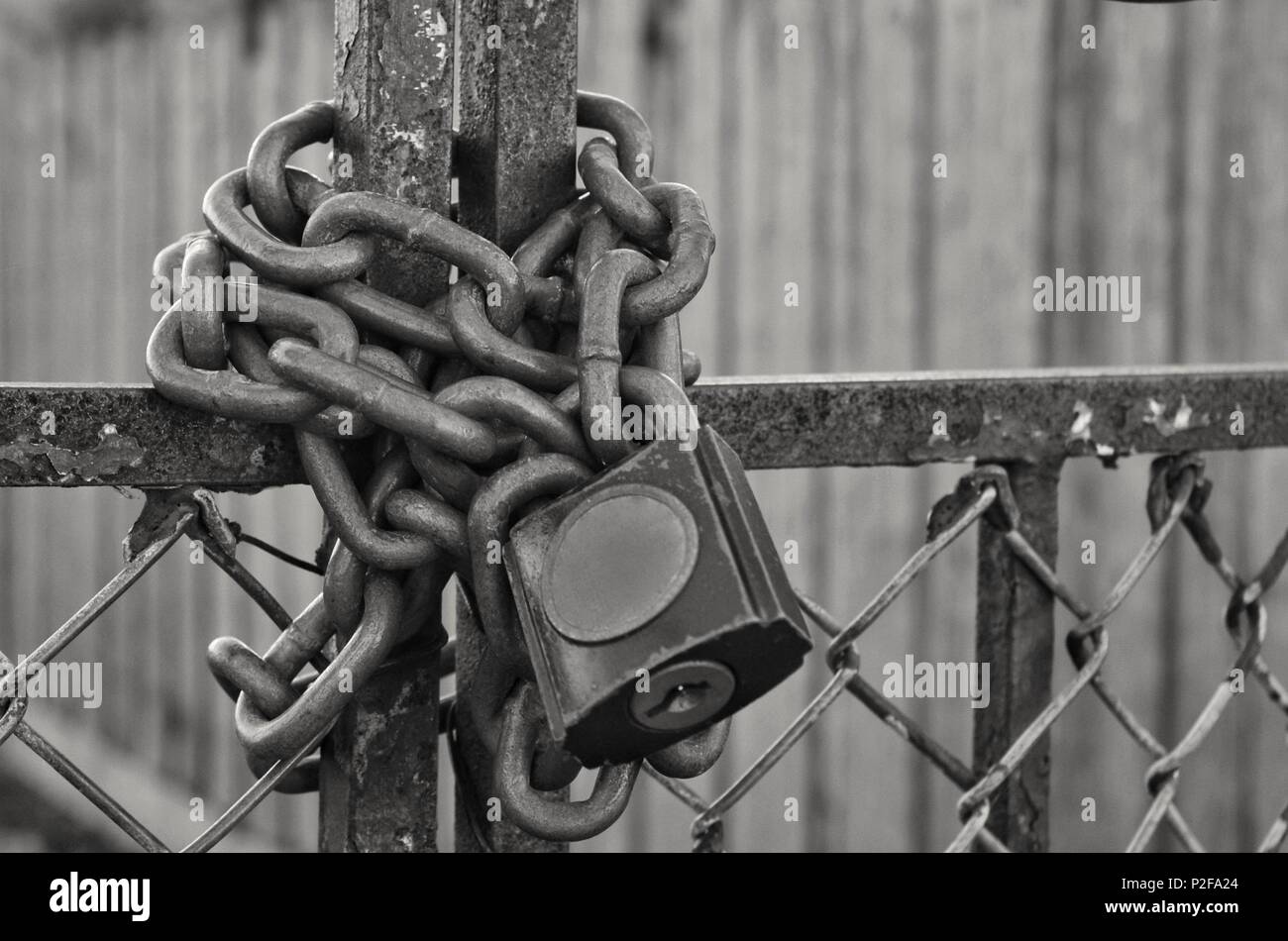 Kette und Vorhängeschloss auf Zaun Stockfoto