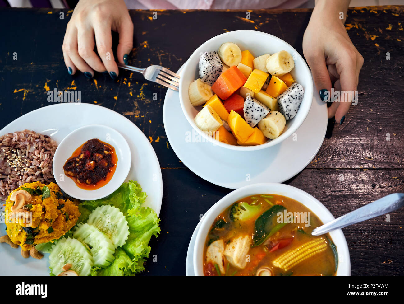 Traditionelle thailändische sauer Suppe Tom Yam in vegetarischen Variation, Curry Reis und Obst Salat in veganes Restaurant in Bangkok. Stockfoto