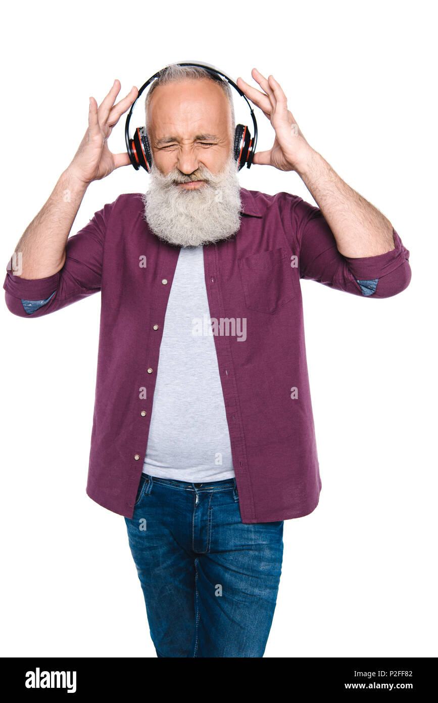 Ältere Menschen mit Kopfschmerzen Musik hören mit Kopfhörern, isoliert auf  weißem Stockfotografie - Alamy