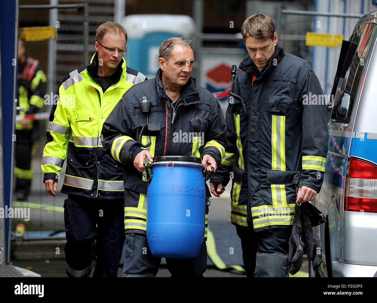 15 Juni 2018, Deutschland, Köln: ein Feuerwehrmann mit einem Faß aus der Wohnanlage Osloer Straße. 3 in Cologne-Chorweiler. Die Polizei ist auf der Suche am Freitag morgen durch mehrere geleert Apartments im Gebäude nach hoch giftigen Ricin wurde dort gefunden. Foto: Oliver Berg/dpa Stockfoto