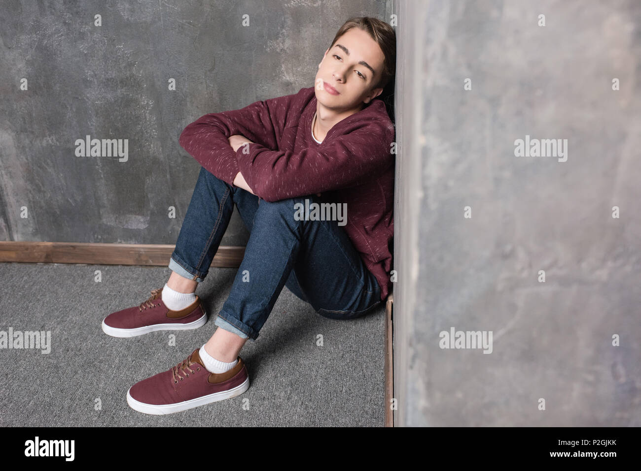 Teenager Junge sitzt auf dem Boden und Wegsehen gedrückt Stockfoto