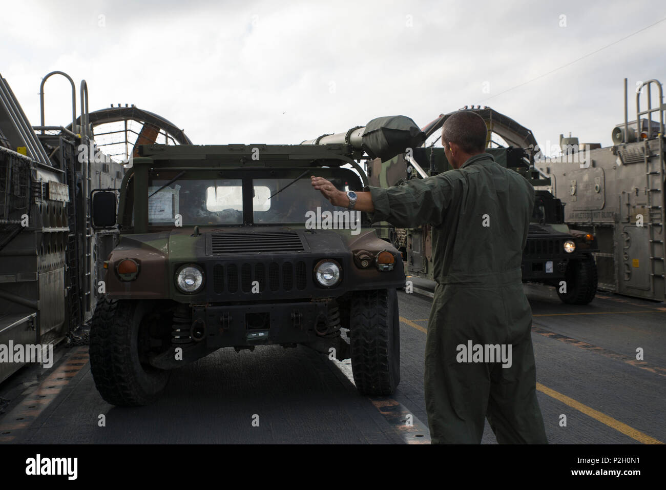 Ein Seemann mit Strand Master Unit 1 leitet ein Humvee Fahrer auf eine Landing Craft Luftkissen Fahrzeug mit Angriff Craft Unit 4 Während ein Schiff als Teil Ihrer PHIBRON/MEU integration Ausbildung bei Onslow Beach, North Carolina Sept. 16, 2016 Ufer an Bord der USS Bataan (LHD-5) in Angriff genommen. Während ein Schiff ans Ufer, LCAC des Schiffes von Meilen vor der Küste zu Räumen, an Land zu kommen und die Marines mit dem 24 Marine Expeditionary Unit und ihre Ausrüstung zurück zum Schiff. PMINT helfen Marines gewöhnen zu arbeiten und leben mit ihrer Marine Gegenstücke auf Schiff und bereitet sie für Stockfoto