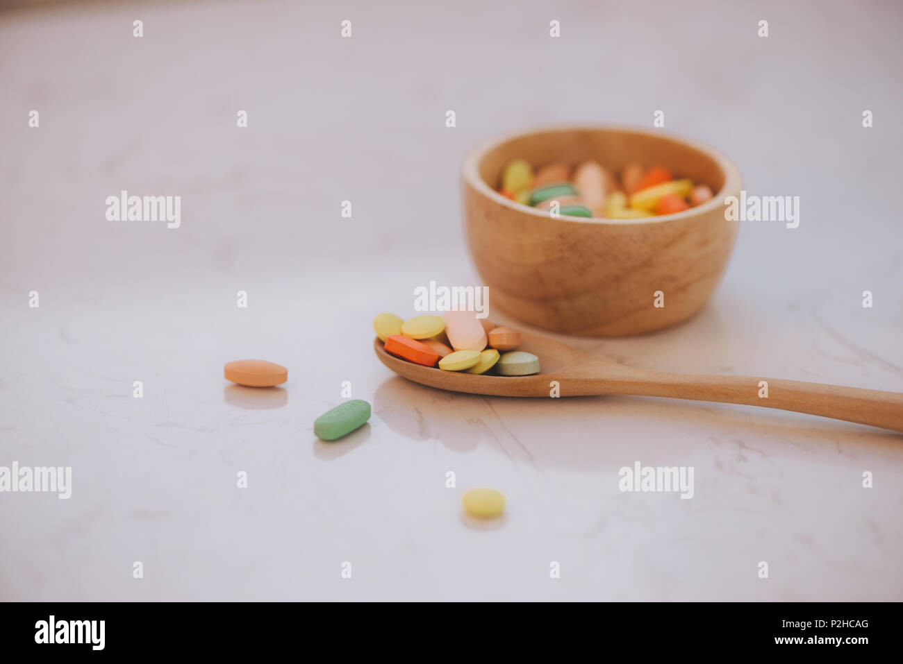 Verschiedene pharmazeutische Medizin Pillen, Tabletten und Kapseln auf hölzerne Schüssel Stockfoto