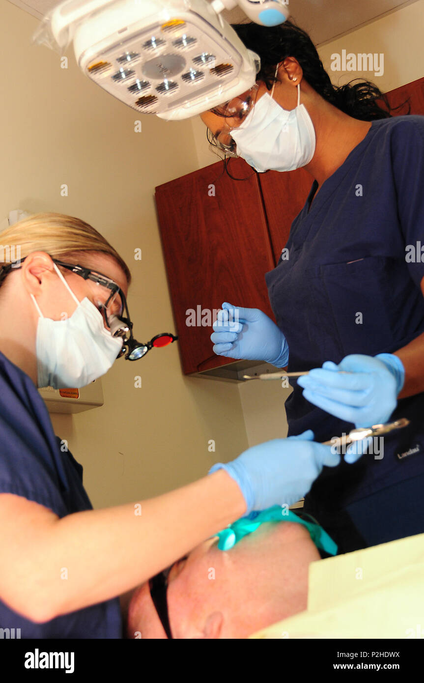 FORT WORTH, Texas (Sept. 26, 2016) Lt.Cmdr. Andrea Haseloff, Zahnarzthelfer an Naval Gesundheit Klinik Fort Worth, Links, und Dionna Sankey, eingetragene Zahnarzthelfer, Zahn Wiederherstellung durchführen auf Senior Master Sgt. Sean Morrison, Betriebsleiter des 221St Combat Communications Squadron, Naval Air Station Fort Worth gemeinsame Mindestreservebasis. Us Navy Foto von Mass Communication Specialist 2. Klasse Jason Howard (Freigegeben) 160927-N-XB 816-017 Stockfoto