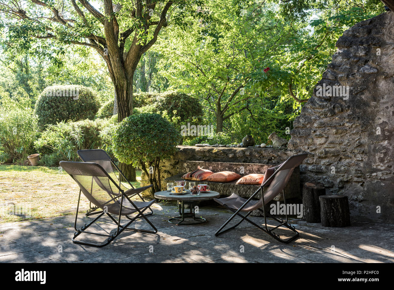 Liegestühlen und Tisch im Schatten des Baumes, Luberon. Stockfoto