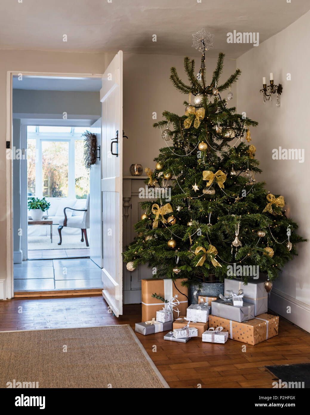 Weihnachtsbaum dekoriert mit Bögen und Kugeln aus dem Land Brocante. Die Wolldecke von Ikea Stockfoto