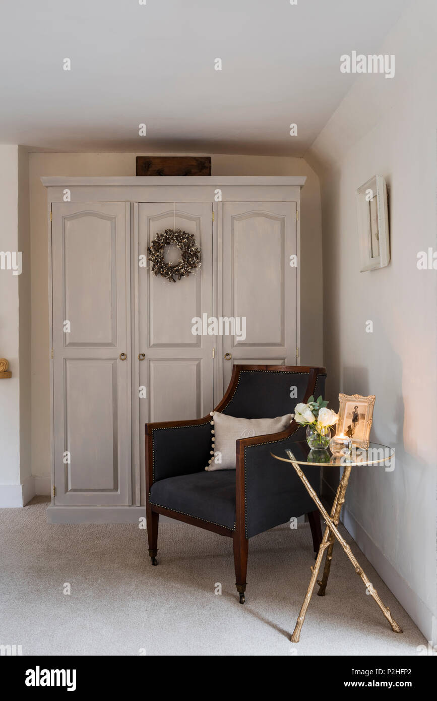 Antiker Stuhl gepolstert in Chelsea Holzkohle Ian Mankin-Architektur in der Ecke des Schlafzimmers. Die Tabelle ist von Graham Green und der Schrank in Pur-lackiert Stockfoto