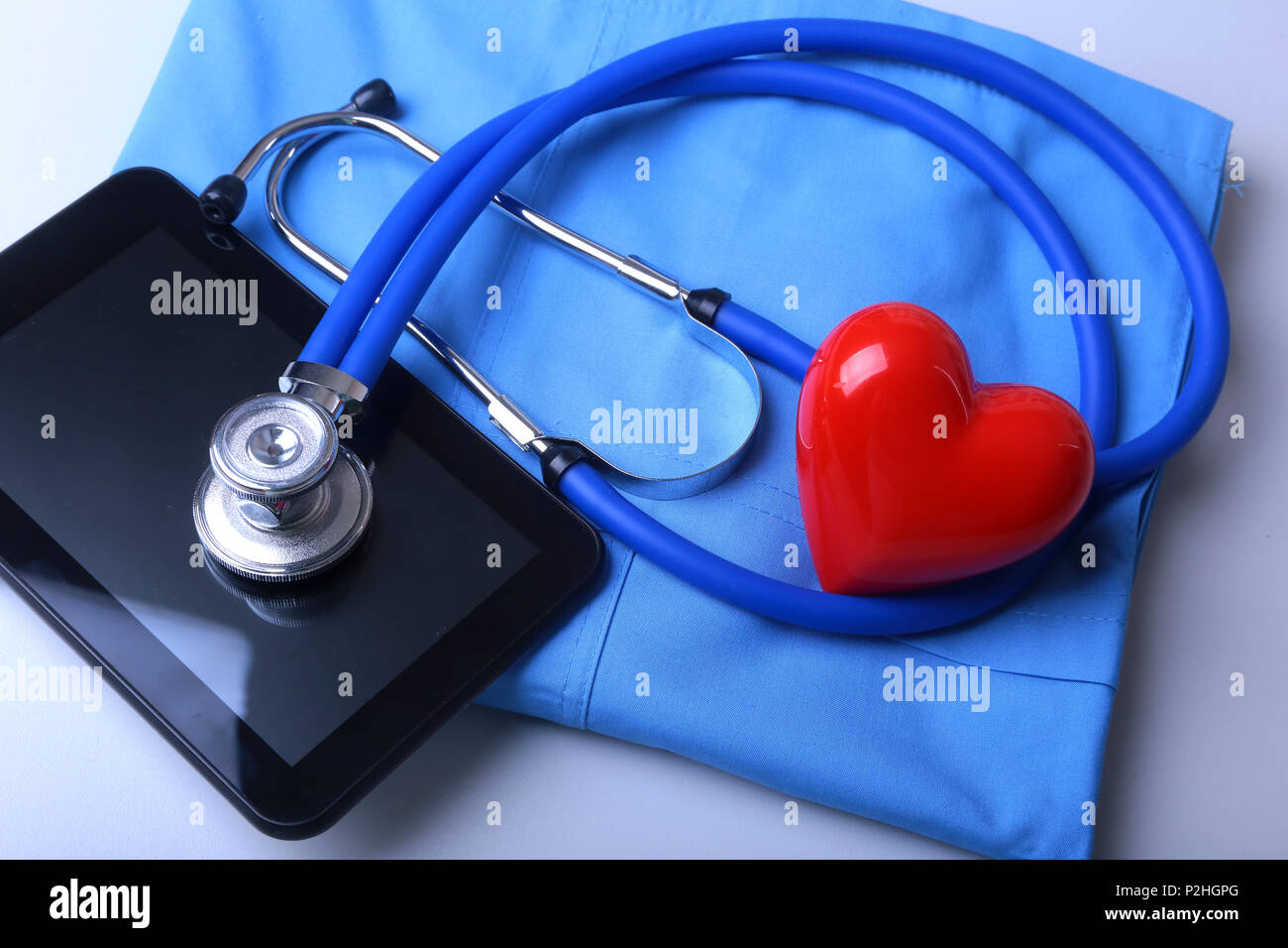 Arzt Mantel mit medizinische Stethoskop und roten Herzen auf den Schreibtisch. Stockfoto
