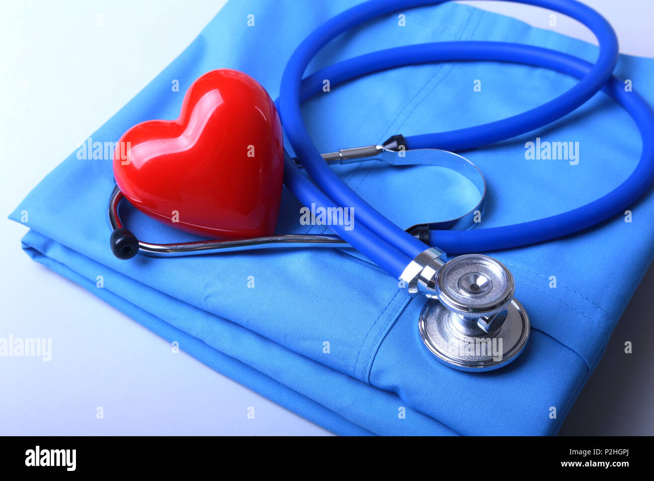Arzt Mantel mit medizinische Stethoskop und roten Herzen auf den Schreibtisch. Stockfoto