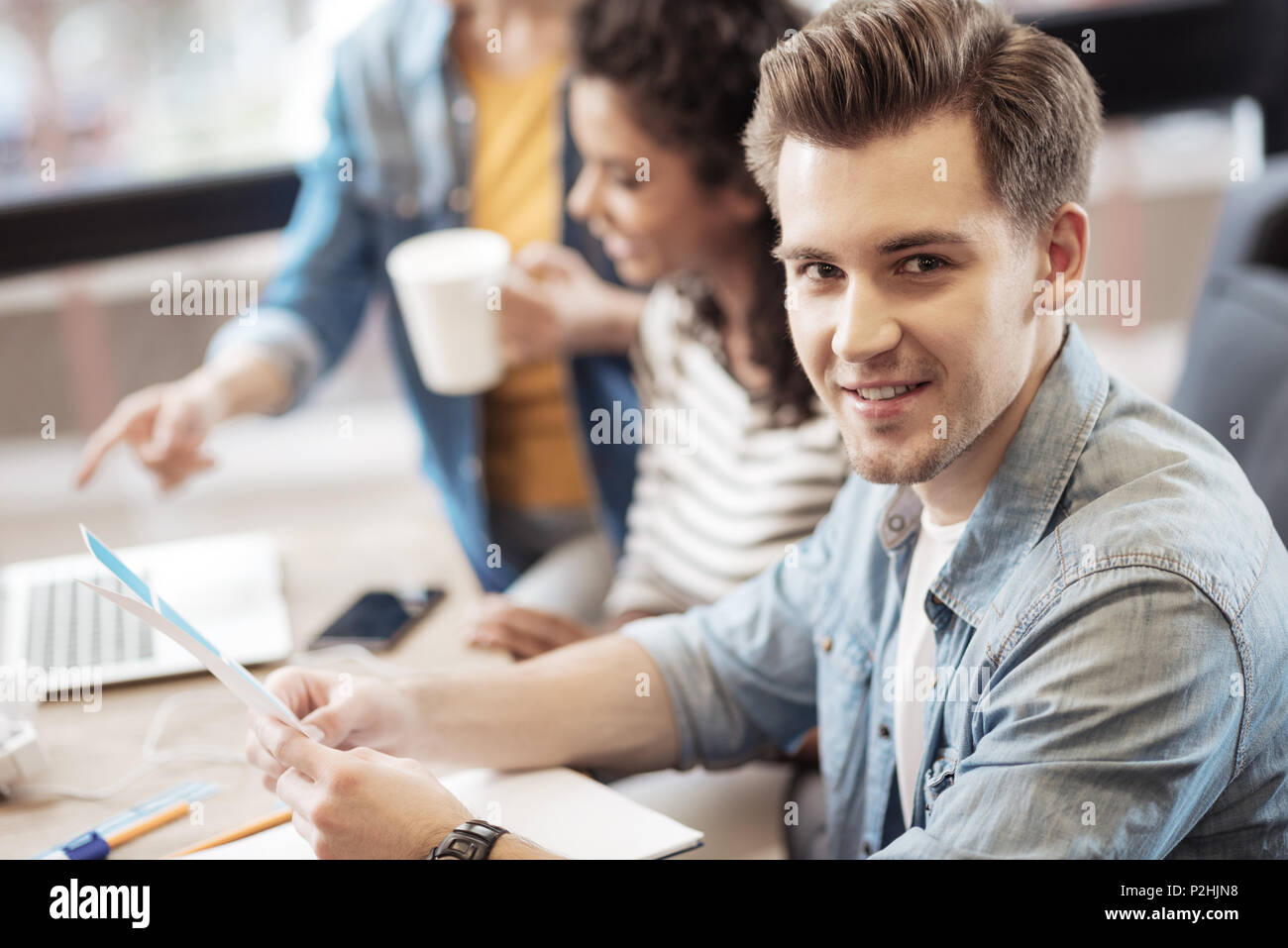 Fröhlicher junger Mann zu Ihnen schauen Stockfoto