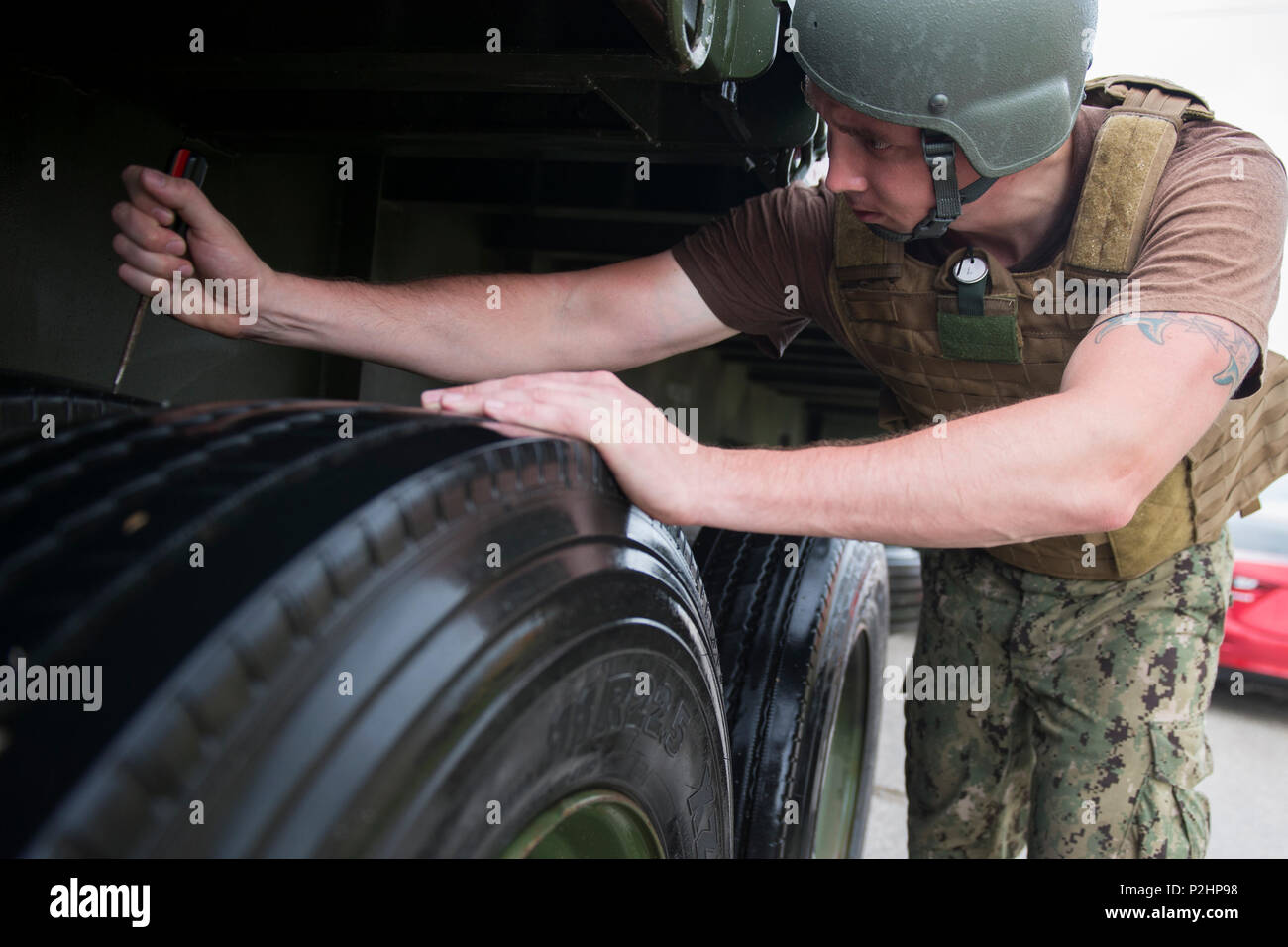 Ein Matrose zu Naval Cargo Handling Bataillon (NCHB) 1, Schmutz genehmigt von einem Lkw Reifen vor der Fahrt auf einem Flugplatz für eine expeditionary Waffen Bewegung Demonstration während der Valiant Shield 2016 bei Andersen Air Force Base, Guam, Sept. 22, 2016 zugeordnet. Valiant Shield ist eine Biennale US Air Force, Navy und Marine Corps Übung in Guam gehalten, die sich auf reale Kenntnisse bei der Aufrechterhaltung der teilstreitkräfteübergreifenden See, in der Luft, an Land und im Cyberspace. (U.S. Marine bekämpfen Kamera Foto von Mass Communication Specialist 1. Klasse Arthurgwain L. Marquez) Stockfoto