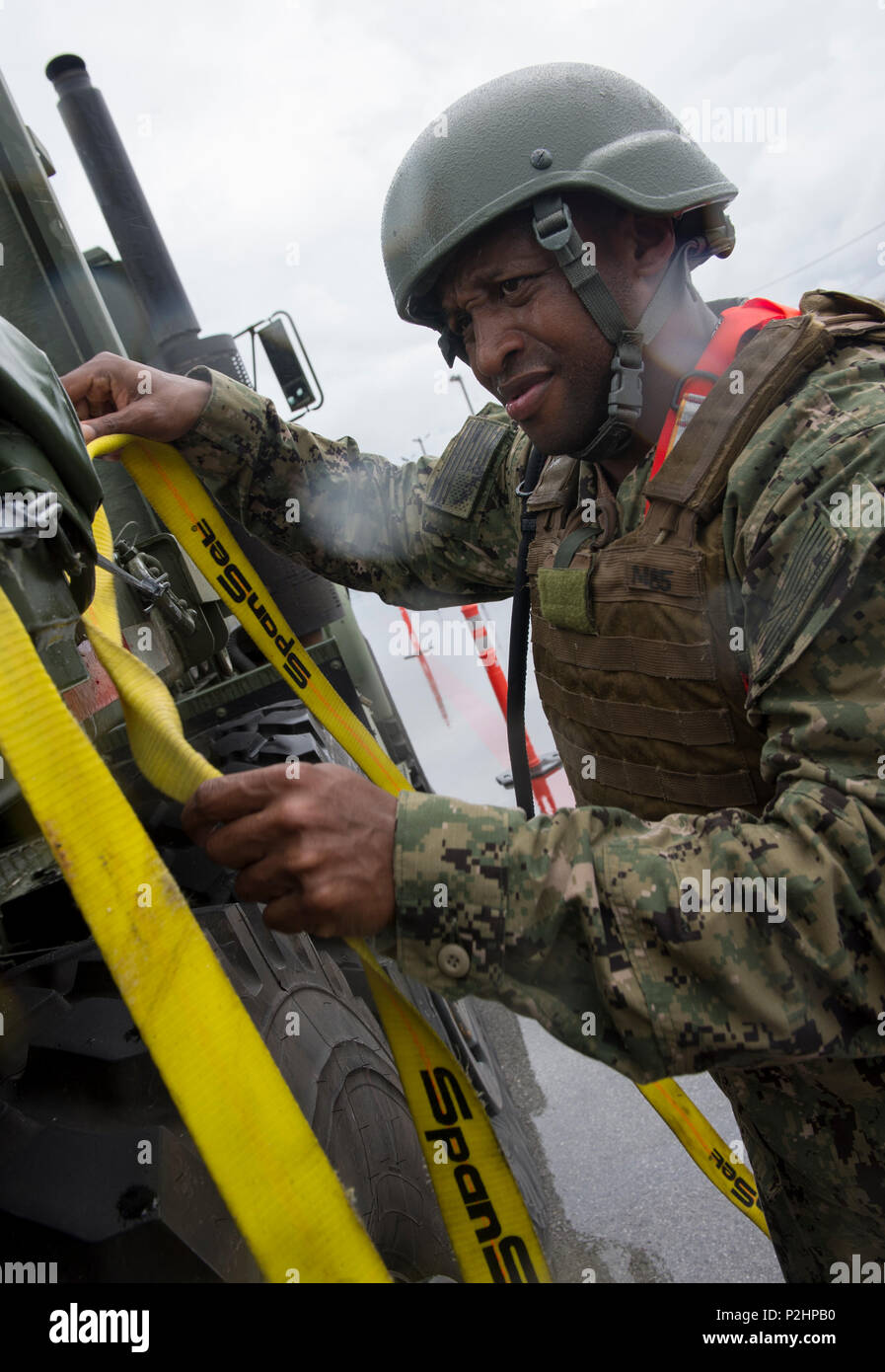 Der Bootsmann Mate 1. Klasse Maurice Bell, zu Naval Cargo Handling Bataillon (NCHB) 1, sichert die Ladung auf einem Tieflader für eine expeditionary Waffen Bewegung Demonstration während der Valiant Shield 2016 in Santa Rita, Guam, Sept. 22, 2016 zugeordnet. Valiant Shield ist eine Biennale US Air Force, Navy und Marine Corps Übung in Guam gehalten, die sich auf reale Kenntnisse bei der Aufrechterhaltung der teilstreitkräfteübergreifenden See, in der Luft, an Land und im Cyberspace. (U.S. Marine bekämpfen Kamera Foto von Mass Communication Specialist 1. Klasse Arthurgwain L. Marquez) Stockfoto