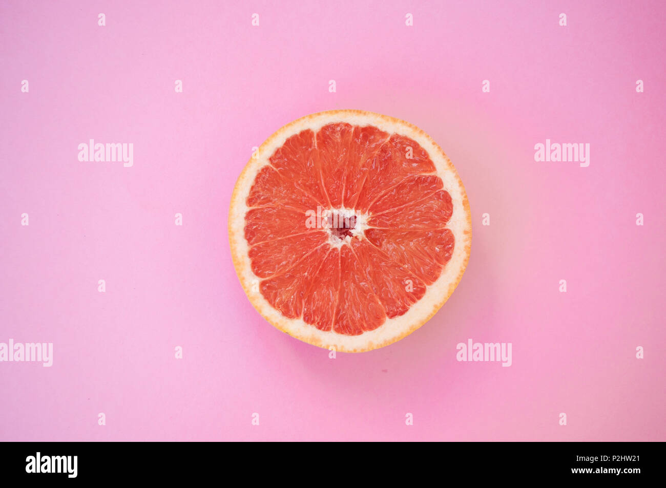 Schön saftig geschnitten Grapefruit auf Pastell rosa Hintergrund. Stockfoto