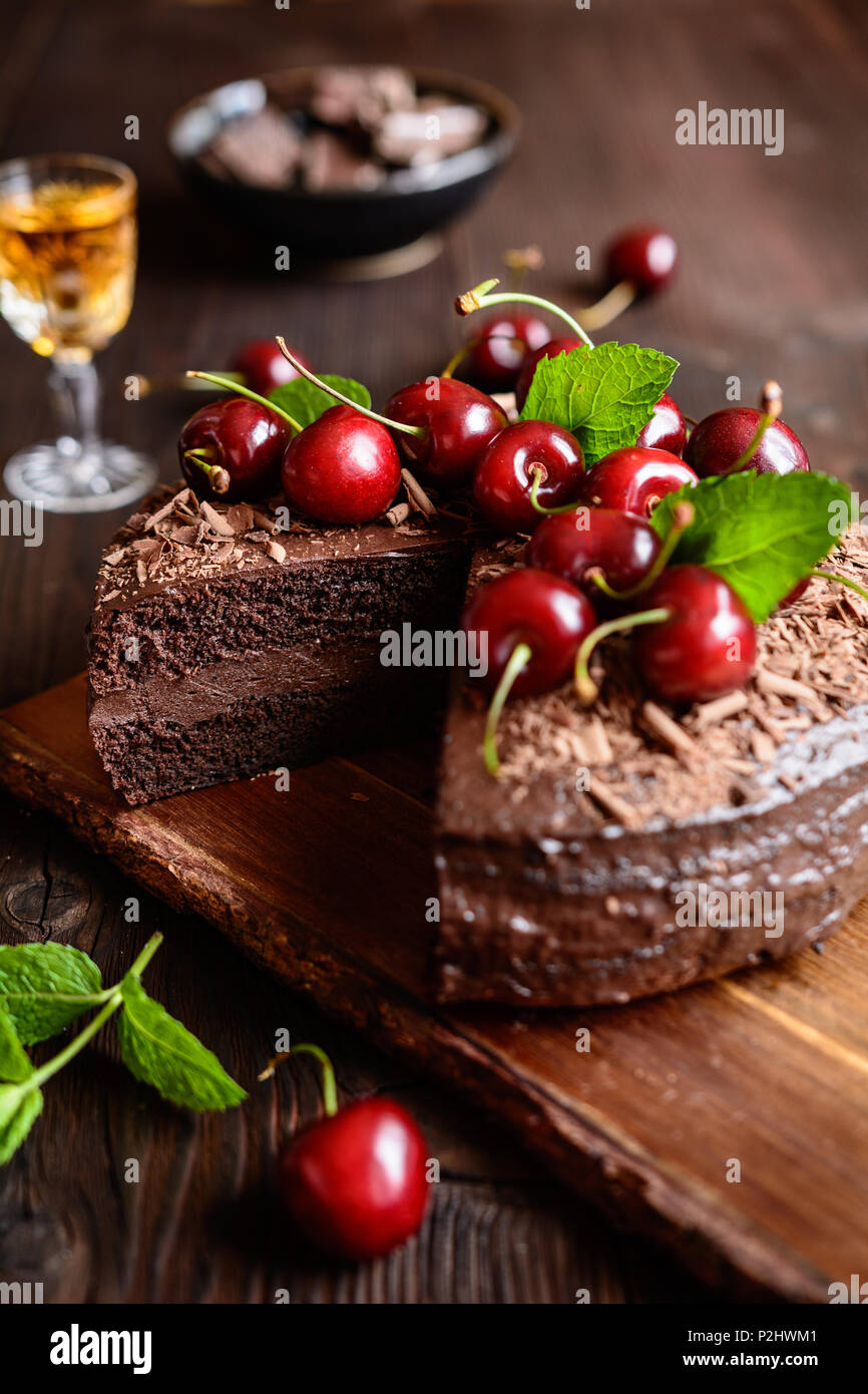 Schokoladenkuchen mit Kakao Schlagsahne gefüllt und mit Schokolade Spänen und Cherry dekoriert Stockfoto