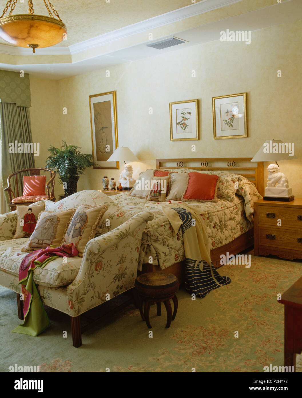 Sofa am Fuß des Betts mit gesteppten Bed - Abdeckung in einem komfortablen Schlafzimmer Stockfoto