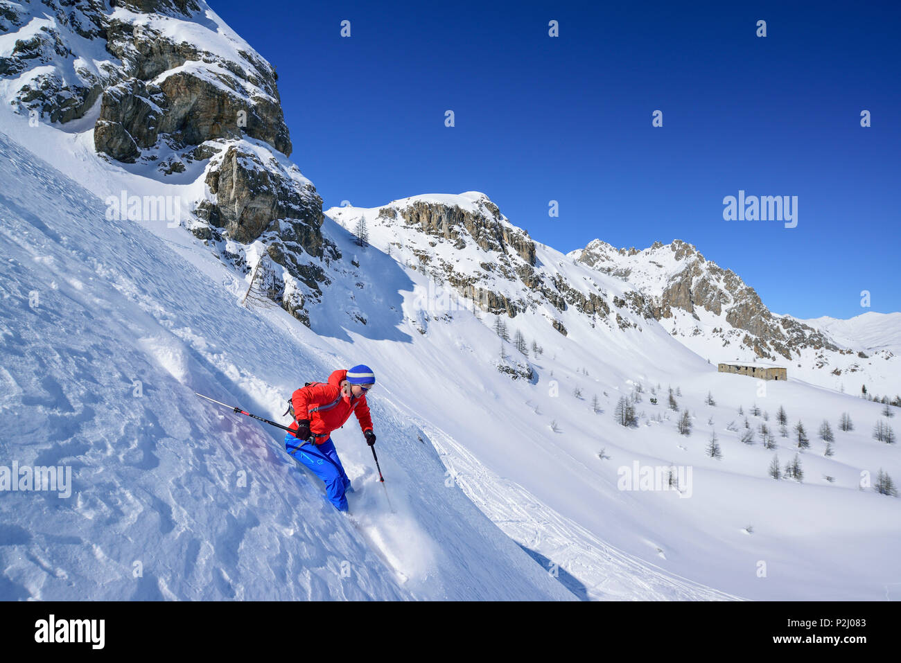 Frau zurück Langlauf Abfahrt durch Tiefschnee von Passo Croce, Passo Croce, Valle Maira, Cottischen Alpen, Piemont, Italien Stockfoto