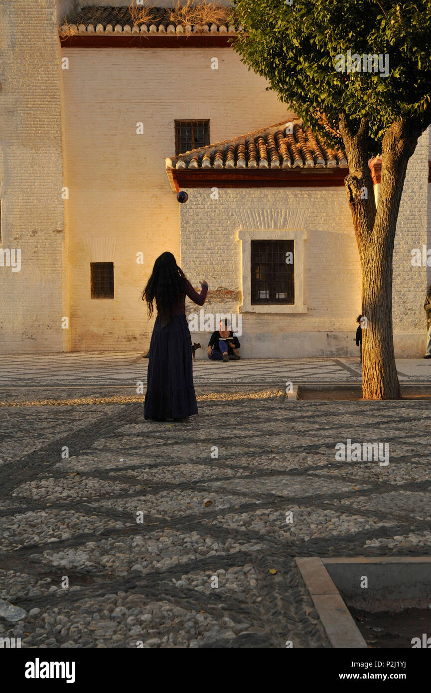 Frau spielen mit einem Ball im warmen Abendlicht am Mirador de San Nicolas, Granada, Andalusien, Spanien Stockfoto