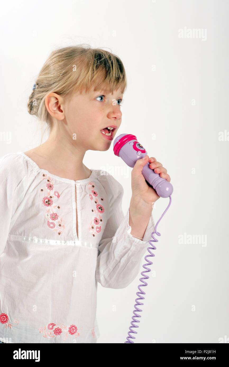 Junge Mädchen in einem Spielzeug Mikrofon singen Stockfoto