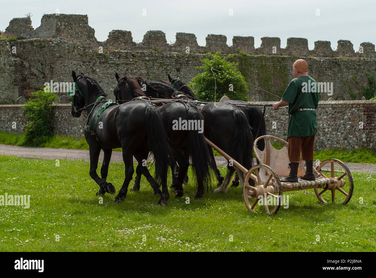 Römisch-antiken Britischen - 4 schwarze Pferd Kampf wagen Demonstration. Lebendige Geschichte Gruppe an Portchester Castle, Hampshire, Großbritannien Stockfoto