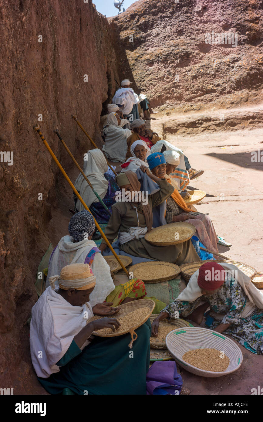 Frauen für sauberes Getreide innerhalb der Grenzen eines Lalibela in Felsen gehauenen Kirchen. Stockfoto
