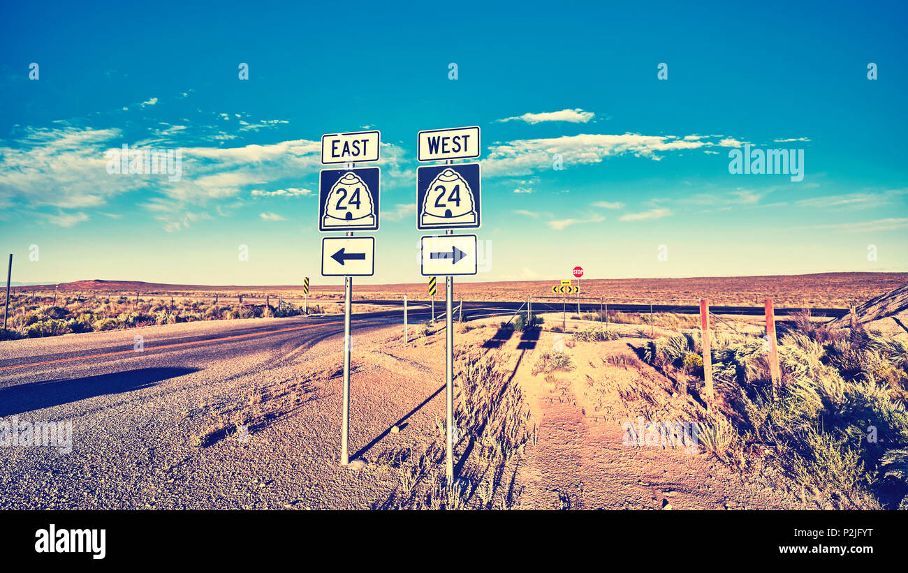 Ost oder West, retro Farben Foto von Verkehrszeichen bei Sonnenuntergang, Auswahl und Travel Concept. Stockfoto