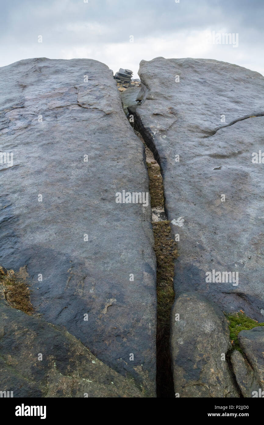 Ein Riss im gritstone Felsen in der Nähe von fairbrook Naze auf Kinder Scout in Derbyshire Peak District, England, Großbritannien Stockfoto