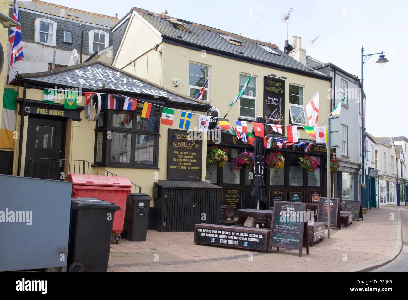 Das Äußere des Dicey Reilly's Pub an der Regent Street, Teignmouth, South Devon angezeigte Land flag Bunting Stockfoto