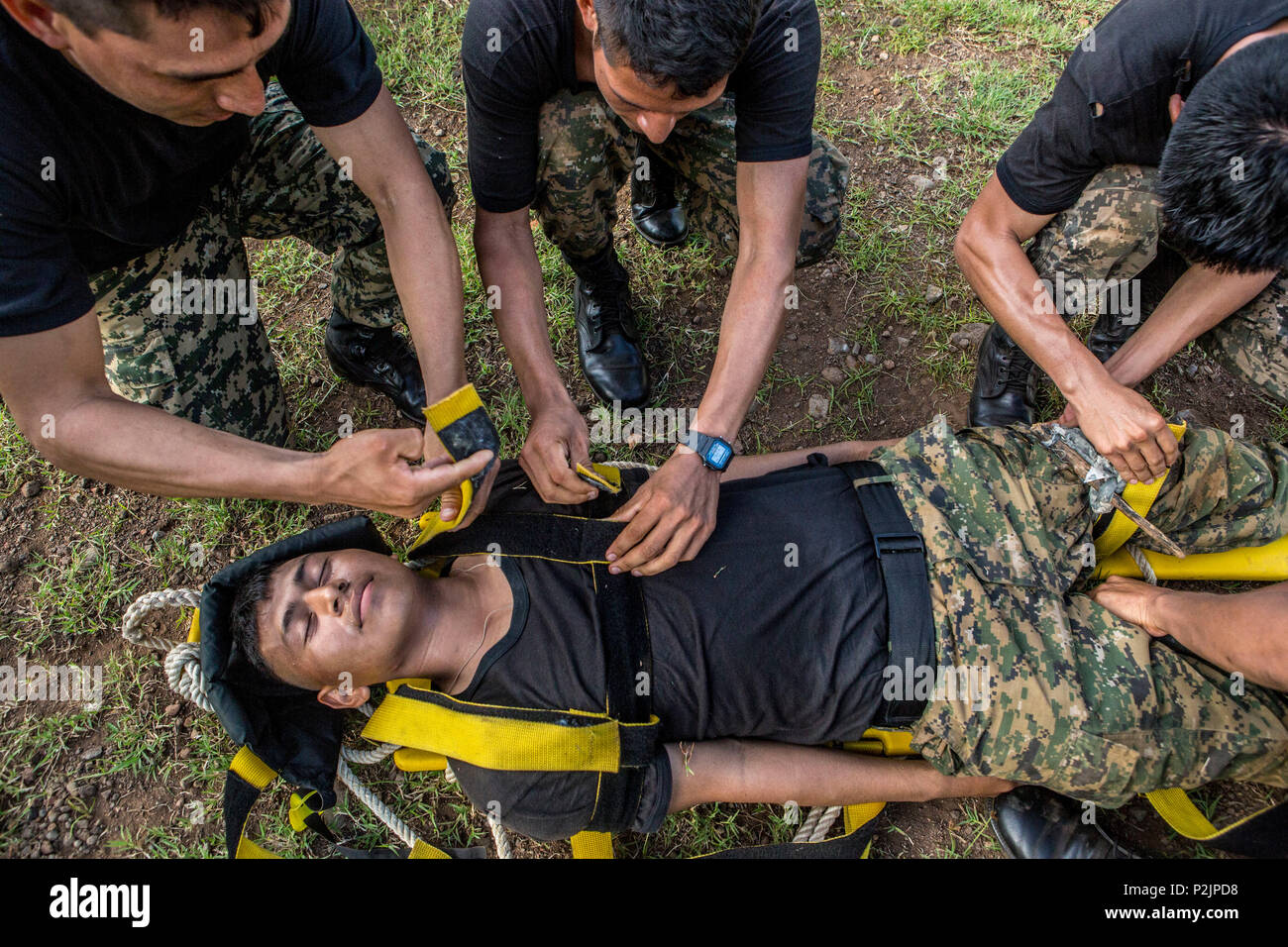 Marines mit der Infante de Marina von El Salvador Praxis unter Verwendung einer Leitkurve Brett während ein lebensretter Klasse, werden Sie wissen, was zu tun ist, wenn einer von ihnen während der combat Life Saver Klasse bei La Union, El Salvador, Sept. 26, 2016 verletzt. In den nächsten Monaten Marinen werden neben ihren El Salvador Gegenparts partner Nation, die Interoperabilität zu verbessern und die regionale Sicherheit und Verteidigung Zusammenarbeit zu stärken. (U.S. Marine Corps Foto von Cpl. Kimberly Aguirre/Freigegeben) Stockfoto