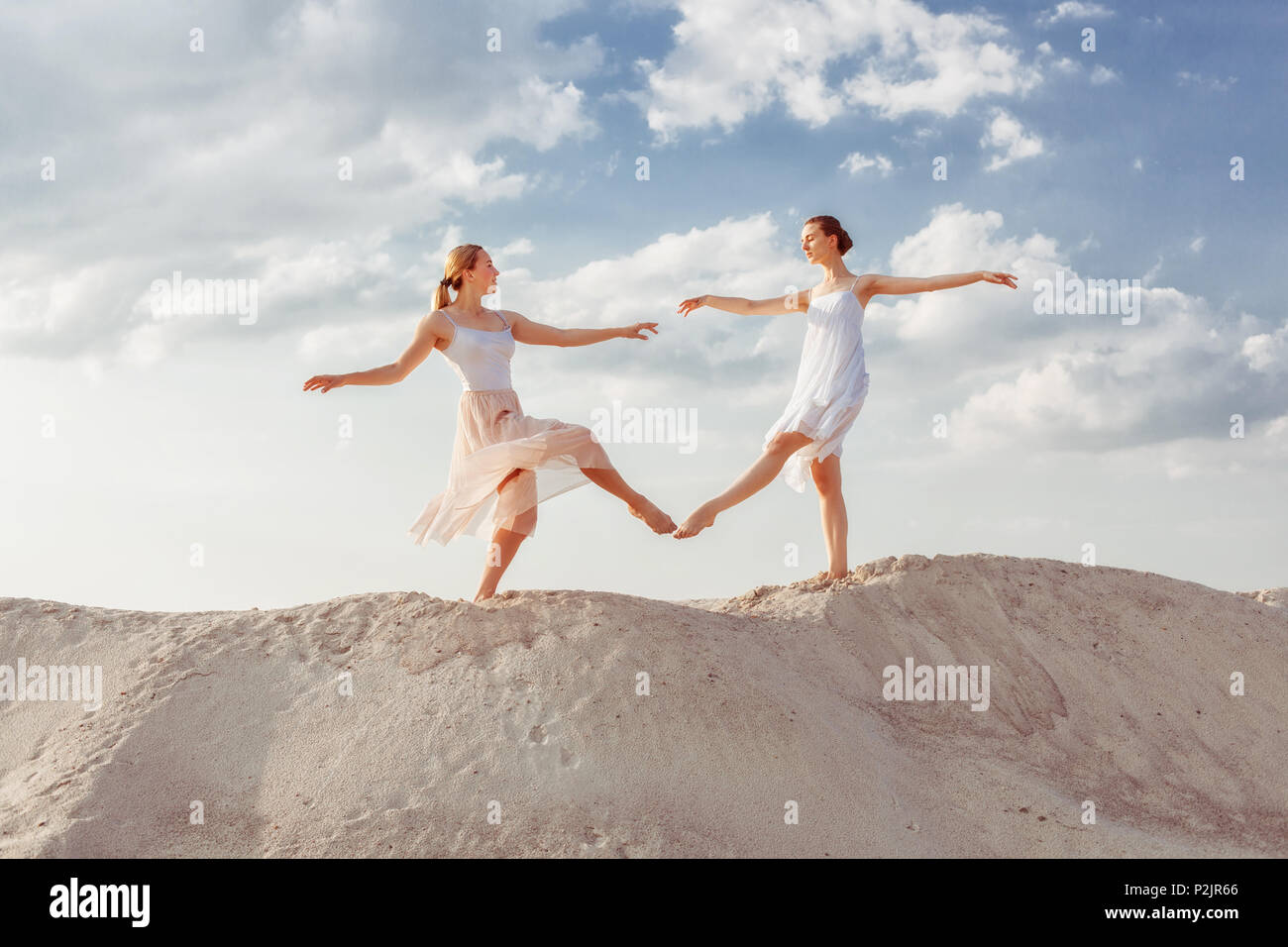 Zwei Tänzer tanzen in der Wüste im Sand, die Sie berühren sich gegenseitig die Füße. Stockfoto