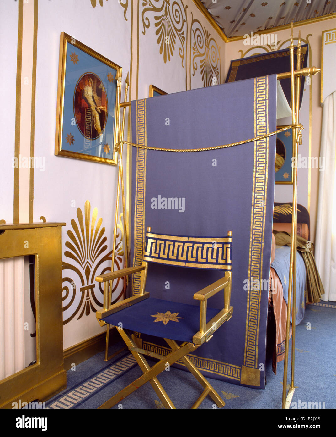 Gold-lackiert Direktor Stuhl mit gold Griechische key Design auf lila  Schlinge gegen Bett mit passenden blau + gold Vordach Stockfotografie -  Alamy