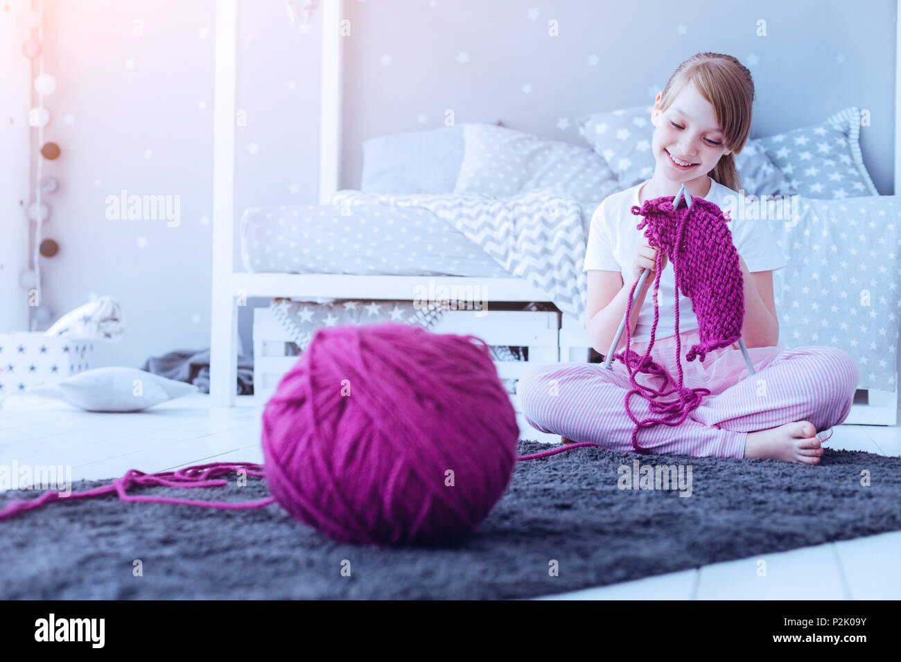 Smart neugierig Mädchen stricken warmer Schal zu Hause Stockfoto
