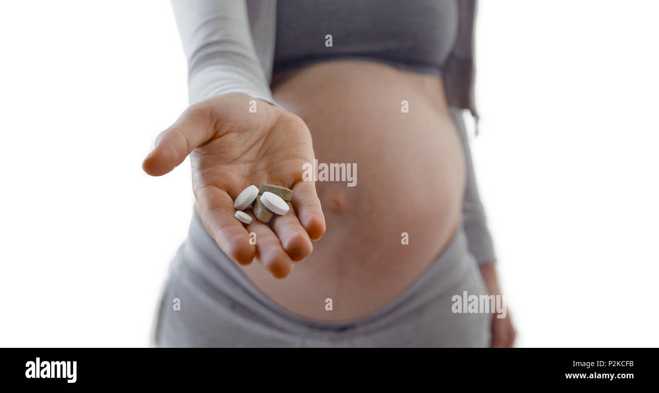 Schwangere Frau Bauch Pillen in der Hand halten Stockfoto
