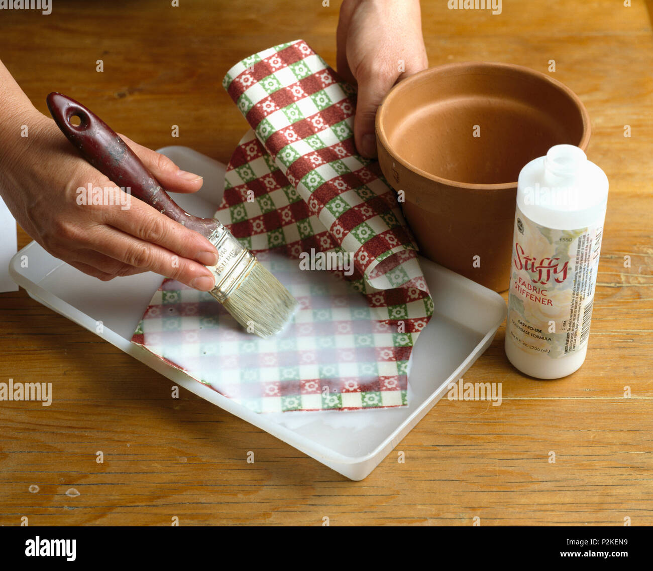 Nahaufnahme der Hand Auftragen von Leim überprüft Papier vor dem Kleben von  Kunststoff Blumentopf Hände einfügen Stoff Versteifung auf gewebe  Stockfotografie - Alamy