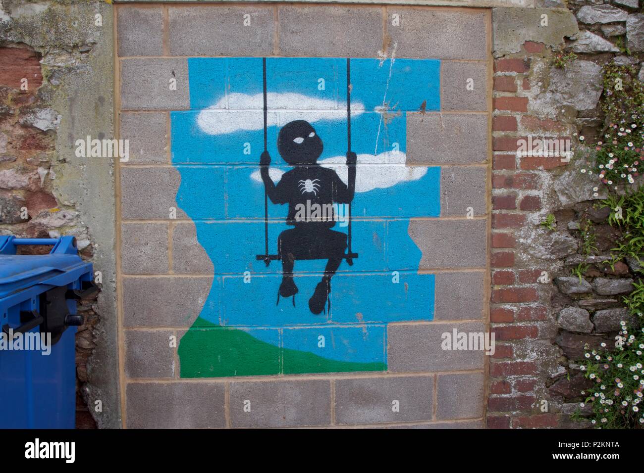 Street Art in Teignmouth, South Devon von die Silhouette eines Jungen mit einer Spinne auf der Brust gefunden, auf der Schaukel Stockfoto