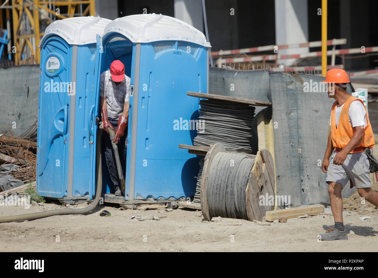 Bukarest, Rumänien - Juni 14, 2018: Ein Arbeiter ist die Entleerung ökologische Toiletten auf einer Baustelle Stockfoto