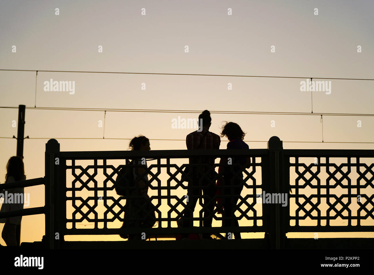 Istanbul, Türkei - 12. Juni 2018: die Silhouetten der einige Leute auf der Galata Brücke in Istanbul. Es gibt Straßenbahn, die Kabel an den Himmel. Stockfoto