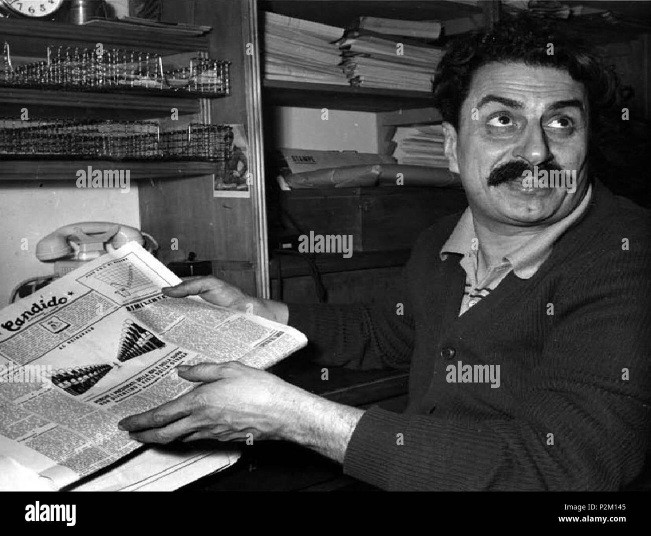 . Italiano: Milano, 1950. Giovannino Guareschi legge il Candido e Mostra vignetta satirica La di Carletto Manzoni contro il Presidente della Repubblica Italiana Luigi Einaudi, eine causa della quale fu processato e con la condizionale condannato a Otto mesi di Carcere. 1950. Foto Farabola 35 Giovannino Guareschi legge il Candido 2 Stockfoto