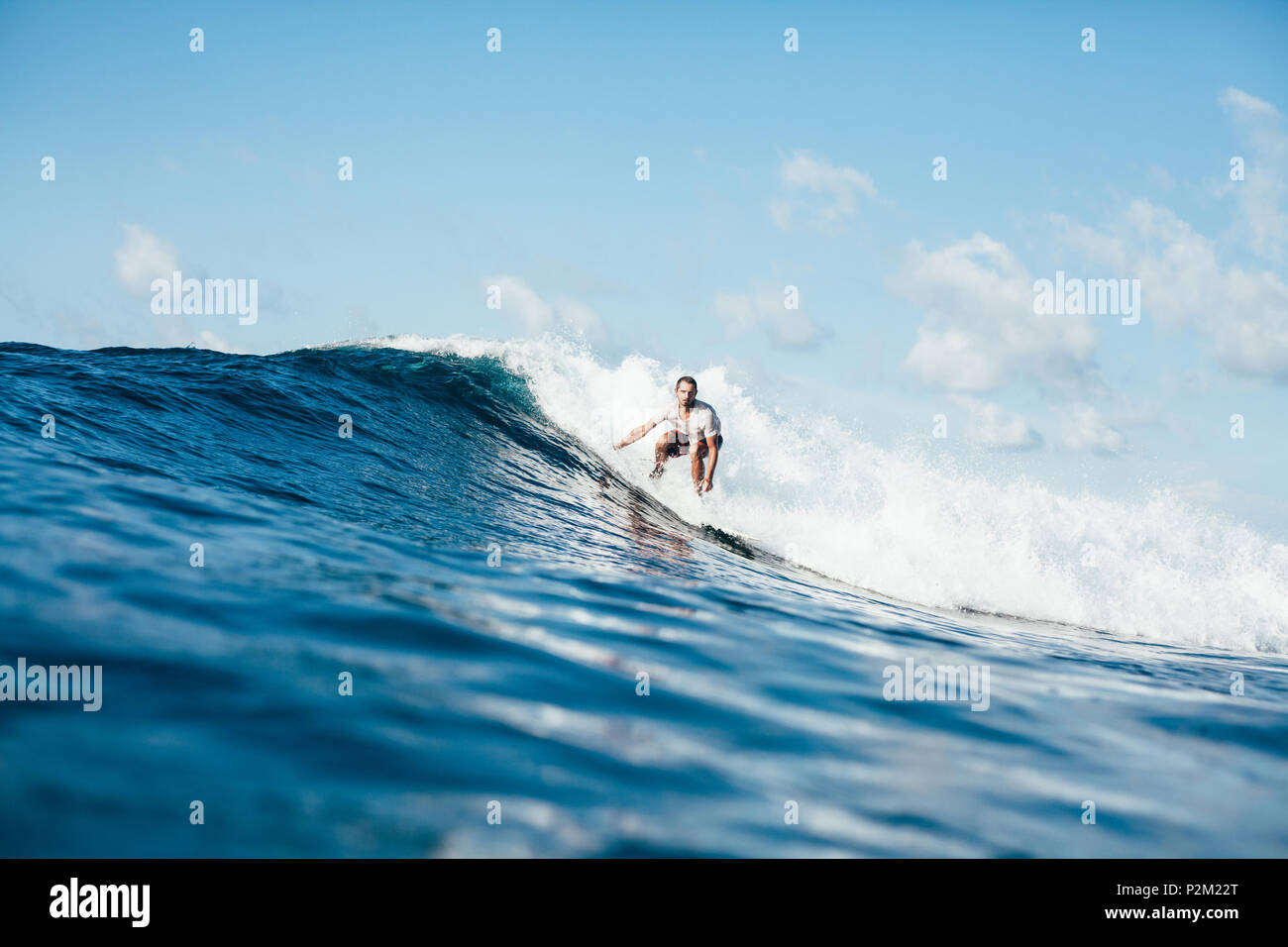 Stattliche Sportler Surfen auf den Wellen an einem sonnigen Tag Stockfoto