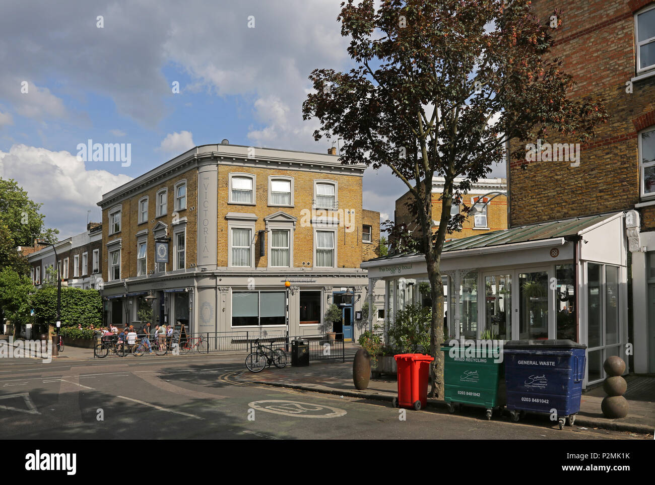 Das Victoria Inn auf der Bellenden Peckham Road, London. An einem Sommerabend mit Kunden von außerhalb in der Sonne sitzend dargestellt. Stockfoto